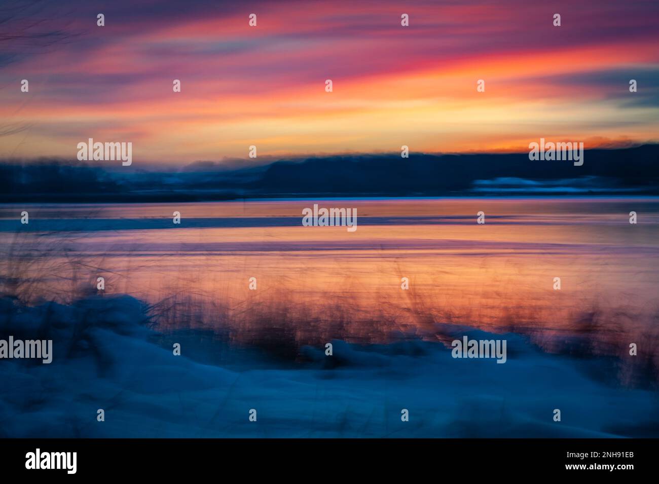 Fotografia intenzionale del movimento della macchina fotografica sulla riva del fiume. Il colore astratto di un tramonto con ICM crea una foto sfocata come un tratto di pittura. Foto Stock