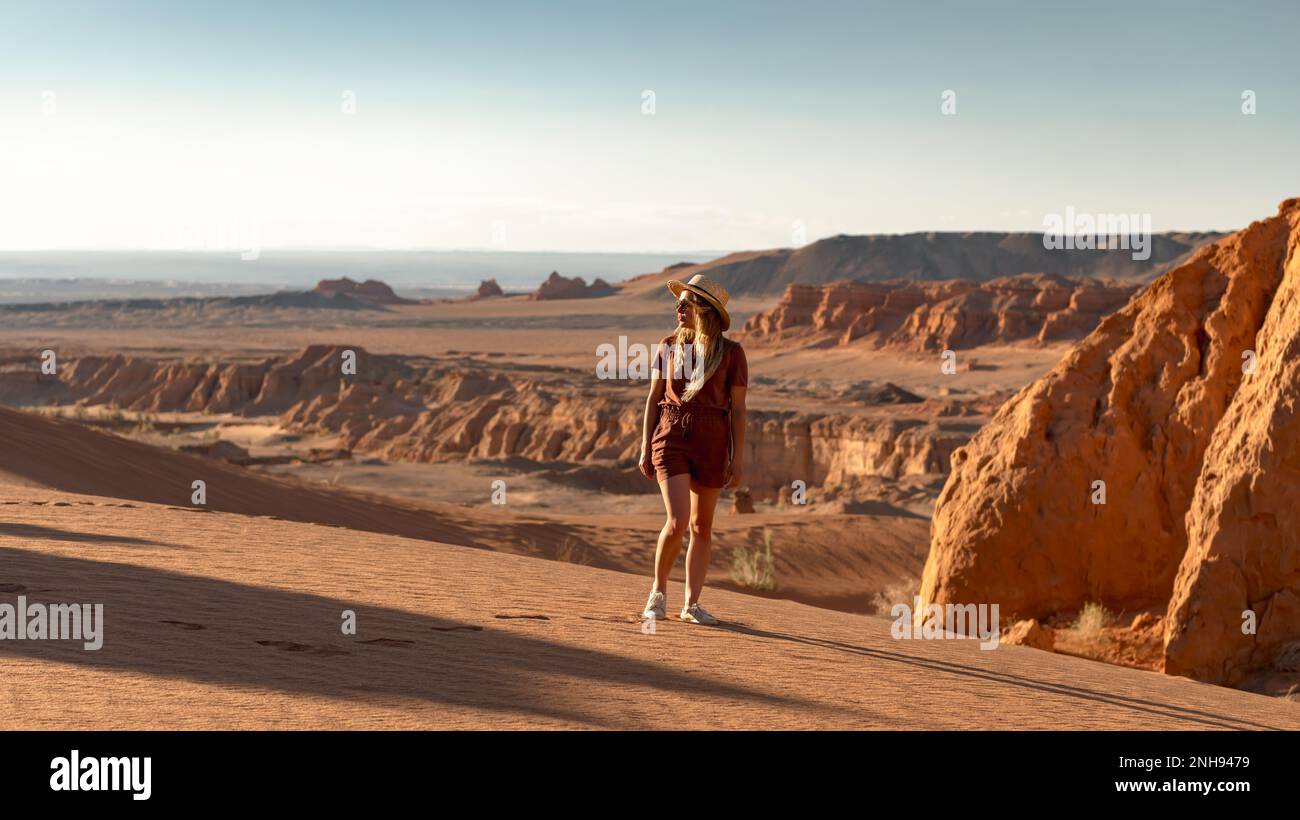 Bella ragazza sorge nel deserto Gobi tramonto e gode della vista Foto Stock