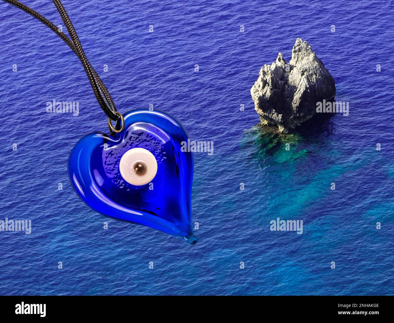 Occhio blu come cham fortunato contro l'acqua di mare blu profondo Foto Stock