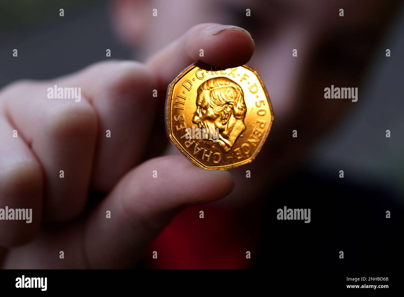 Isabelle, 11 anni, con la prima moneta del re Carlo III 50p a Sussex, Regno Unito. Foto Stock