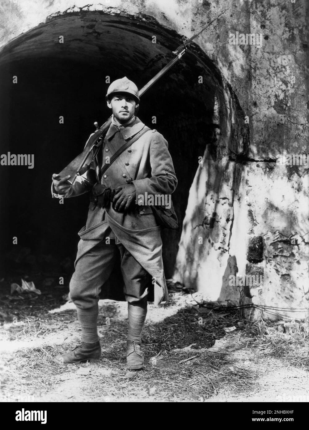 1921 , USA : l'attore cinematografico silenzioso RUDOLPH VALENTINO ( Rodolfo Guglielmi , 1895 - 1926 ) ancora publicitaria per I QUATTRO CAVALIERI DELL'APOCALISSE di Rex Ingram , Dal romano di Blasco Ibanez - CINEMA MUTO - RODOLFO - attore cinematografico - LATINO LOVER - italoamericano - italo americano - italo-americano - emigrante - emigrante - italo-americano - ritratto - ritratto - divisa militare - divisa uniforme militare - zardo magnetico - elmetto - casco - fucile - Pistola - baionetta - barba - pizzetto - barba ---- Archivio GBB Foto Stock