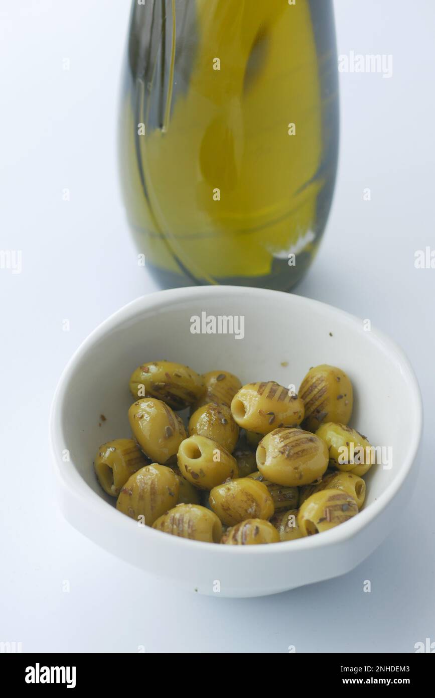 Olive alla griglia turche con vasetto di olio e olive sul tavolo Foto Stock