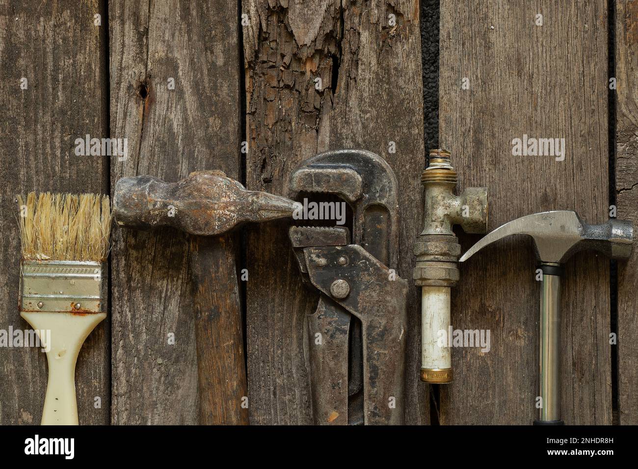gas chiave martello vecchio tubo arrugginito e pennello giacere su un tavolo di legno in cucina, riparazione, set di utensili Foto Stock
