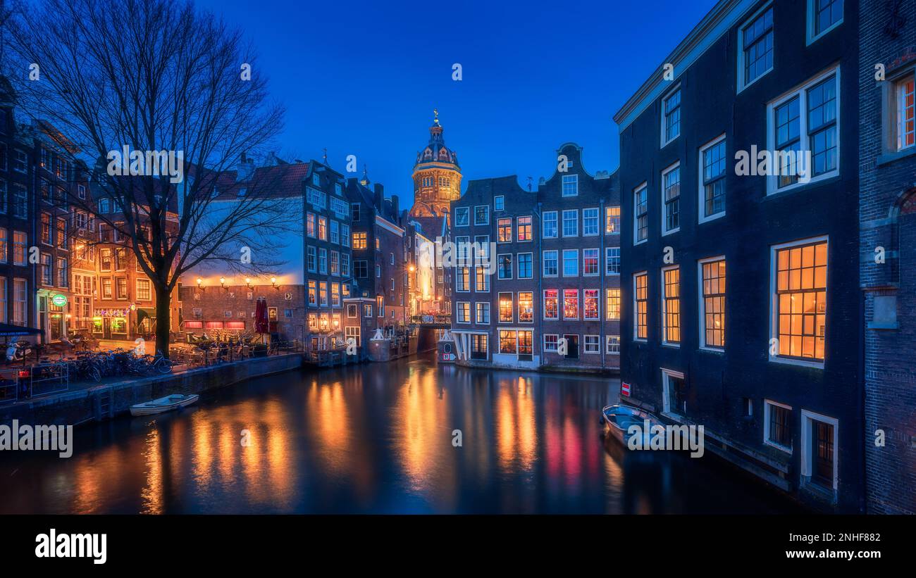 Notte di Amsterdam, notte quartiere a luci rosse con finestre colorate vicino alla basilica di san nicola Foto Stock