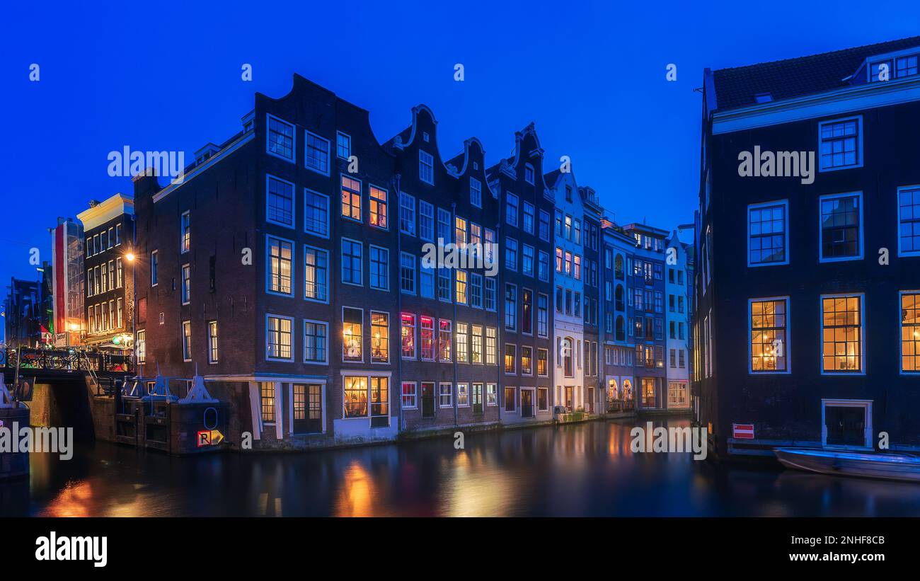 Notte di Amsterdam, notte quartiere a luci rosse con finestre colorate vicino alla basilica di san nicola Foto Stock