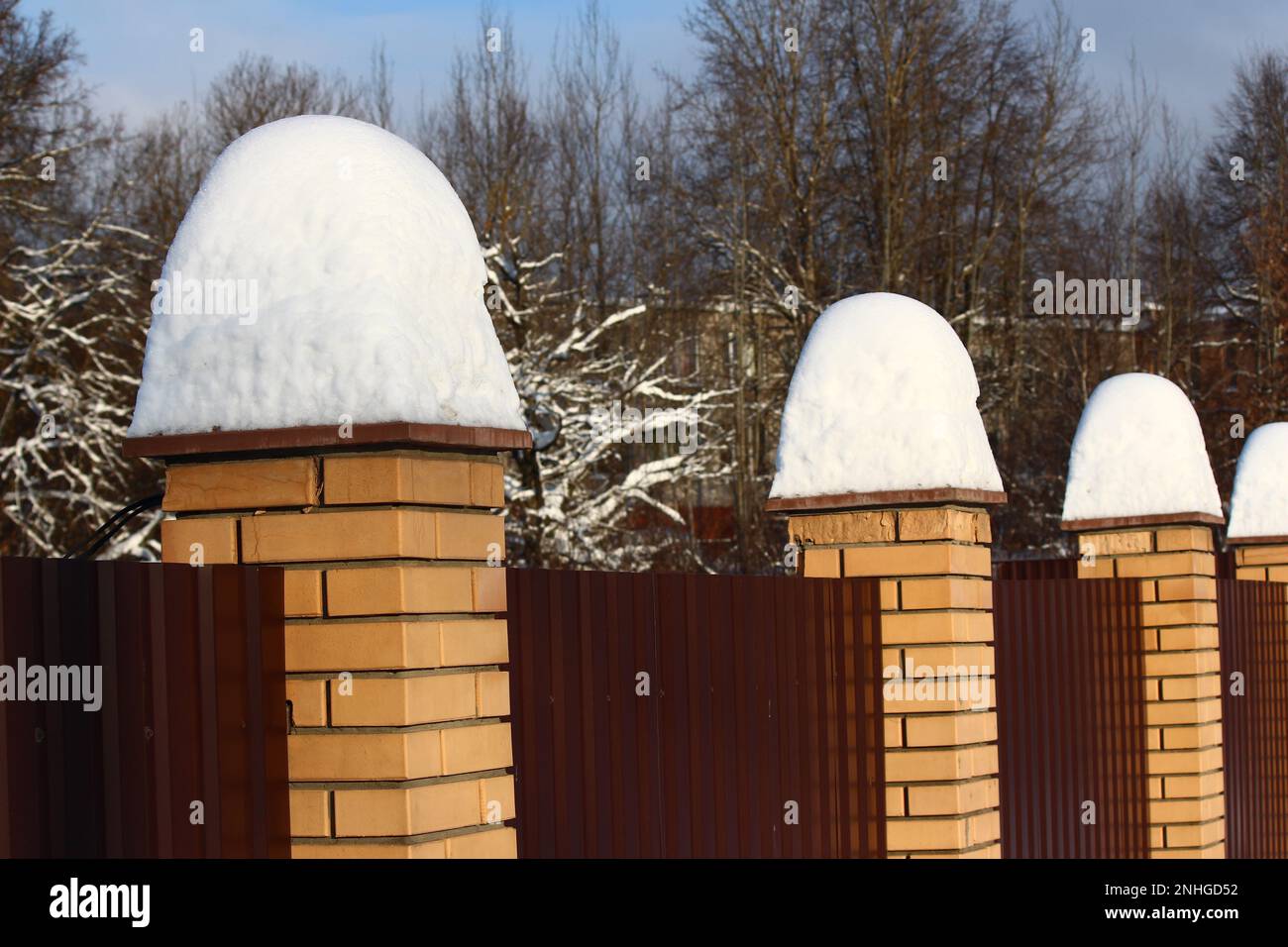 Alti mucchi di neve dopo una caduta di neve su una recinzione in una giornata invernale Foto Stock