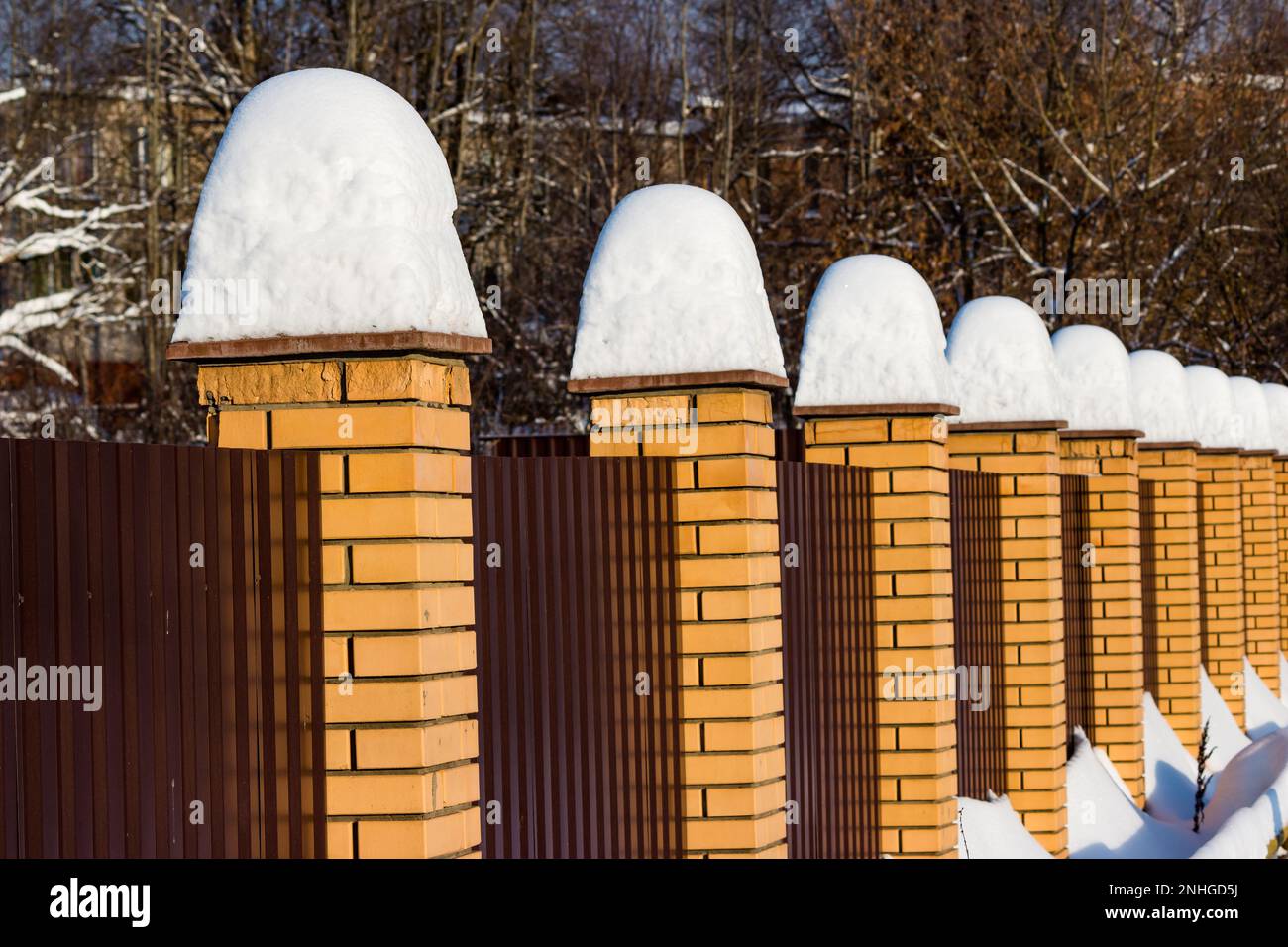 Alti mucchi di neve dopo una caduta di neve su una recinzione in una giornata invernale Foto Stock