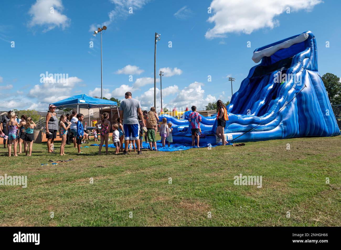 Le famiglie militari aspettano in fila per scendere da uno scivolo d'acqua durante un Back to School Field Day alla Moody Air Force base, Georgia, 29 luglio 2022. L'Airman e il Family Readiness Center dello Squadrone di supporto della forza 23rd si sono alleati con il Freedom One Fitness Center per restituire il terreno alla comunità militare ospitando la Field Day. Foto Stock