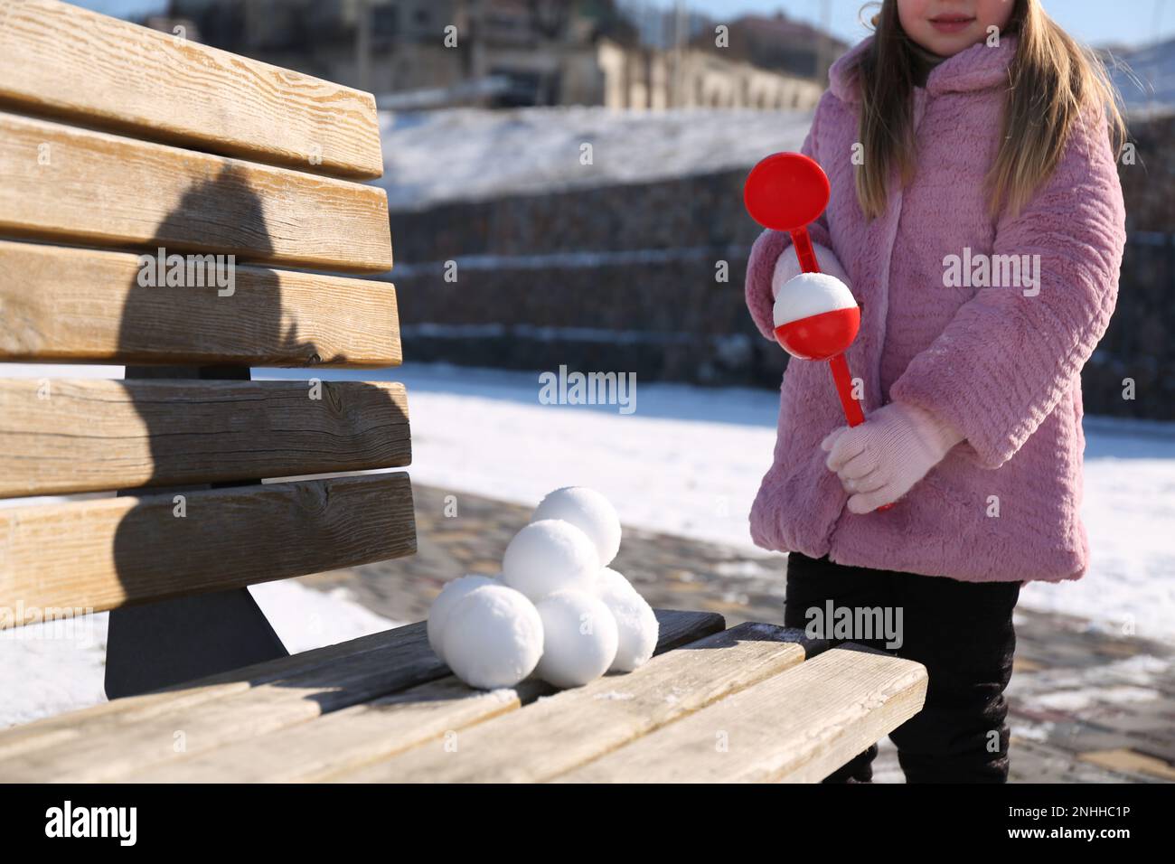 Bambina che gioca con il costruttore di palle di neve all'aperto, primo piano Foto Stock