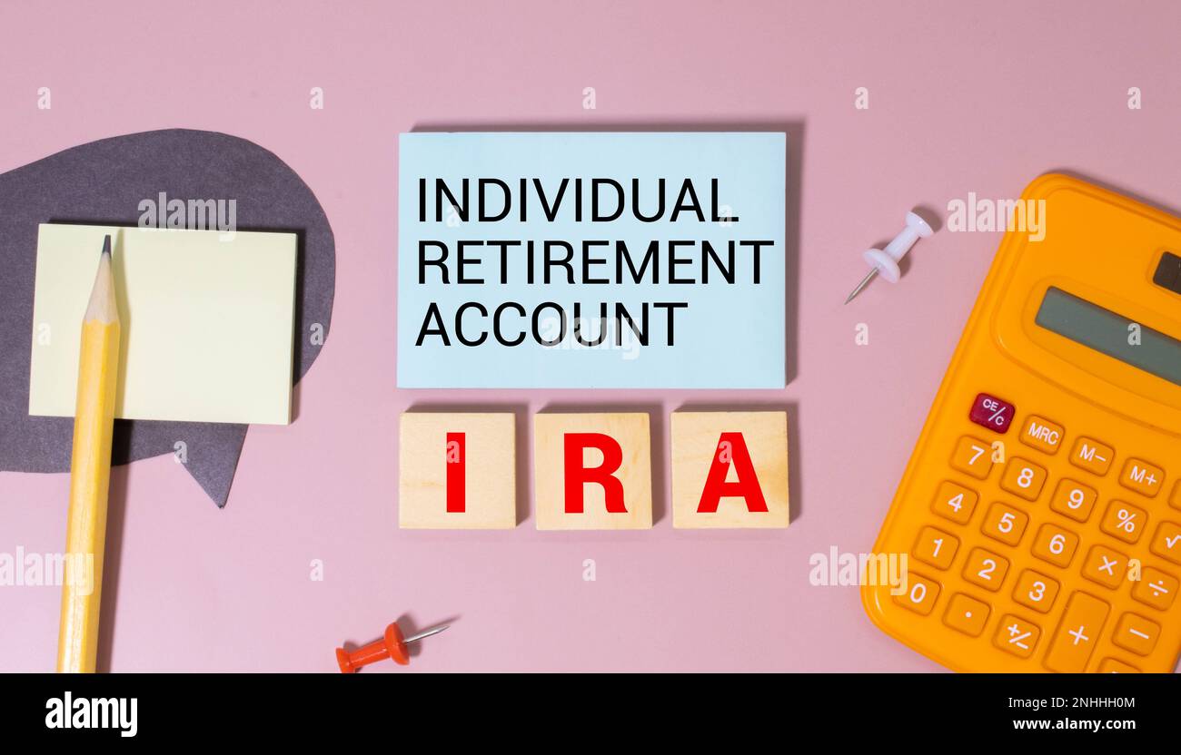 Su uno sfondo blu brillante, blocchi e cubi di legno chiaro con il testo IRA Individual Retirement account. Foto Stock
