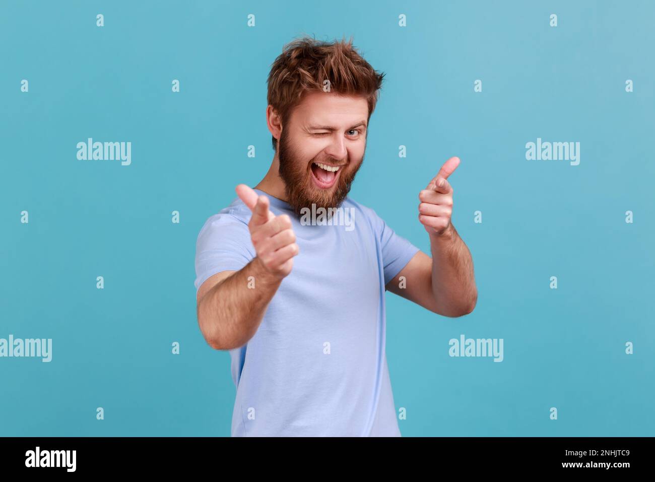 Sei speciale. Ritratto di uomo felice positivo bearded che punta le dita alla macchina fotografica e guardando con sorriso toothy, crede in voi, motivazione. Studio in interni isolato su sfondo blu. Foto Stock