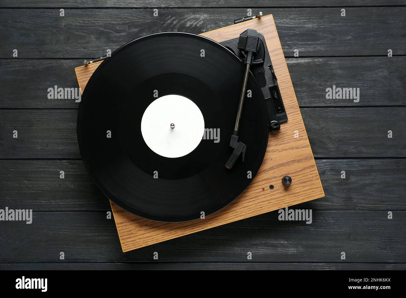Giradischi con disco in vinile su sfondo di legno nero, vista dall'alto Foto Stock