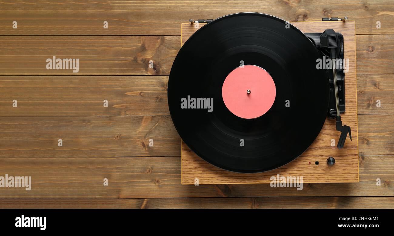 Giradischi con disco in vinile su sfondo in legno, vista dall'alto Foto Stock