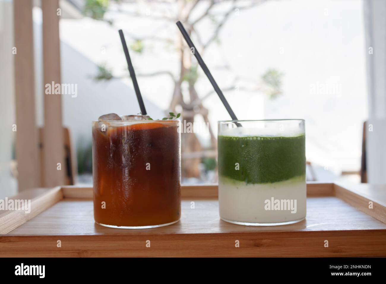 Americano ghiacciato con tè verde matcha arancione e ghiacciato nella caffetteria, foto di scorta Foto Stock