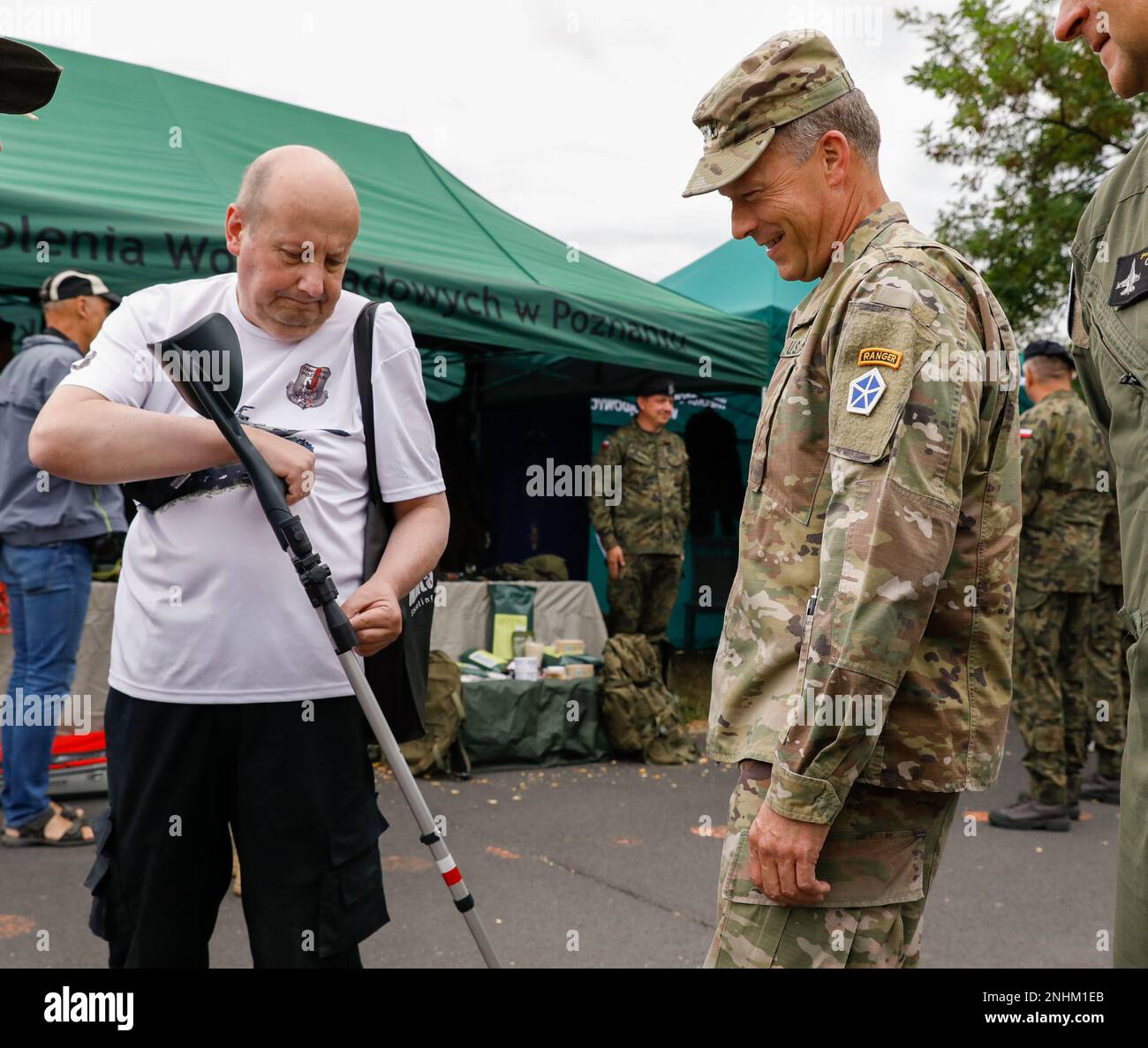 STATI UNITI John Kolasheski, comandante del V corpo, parla con un cittadino polacco durante una mostra statica a Poznan, Polonia, 30 luglio 2022. I soldati della squadra di combattimento della Brigata Armorata del 3rd, della divisione di Fanteria del 4th e della divisione di Fanteria del 1st, hanno tenuto una mostra statica e un picnic con gli alleati polacchi, in celebrazione della ridenominazione del sito operativo di marcia avanti Poznan, e di interagire con la comunità intorno ai soldati schierati in Polonia. Foto Stock