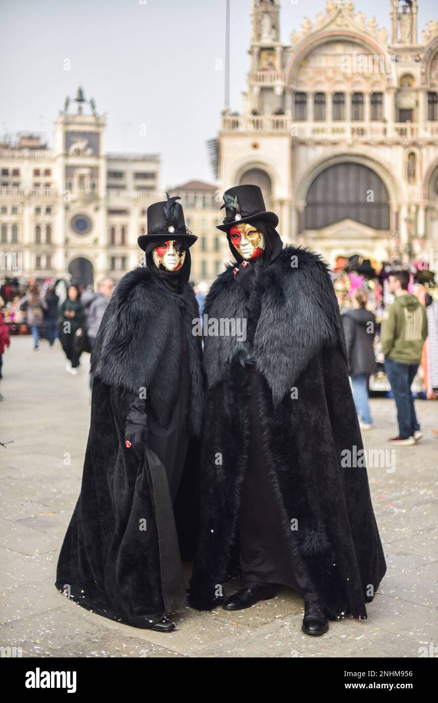 18 febbraio 2023, Venezia, Italia: Indossare cappe nere, partecipanti in  costume durante il Carnevale delle maschere di Venezia in Piazza San Marco.  Le origini del Carnevale veneziano sono oscure. La leggenda vuole
