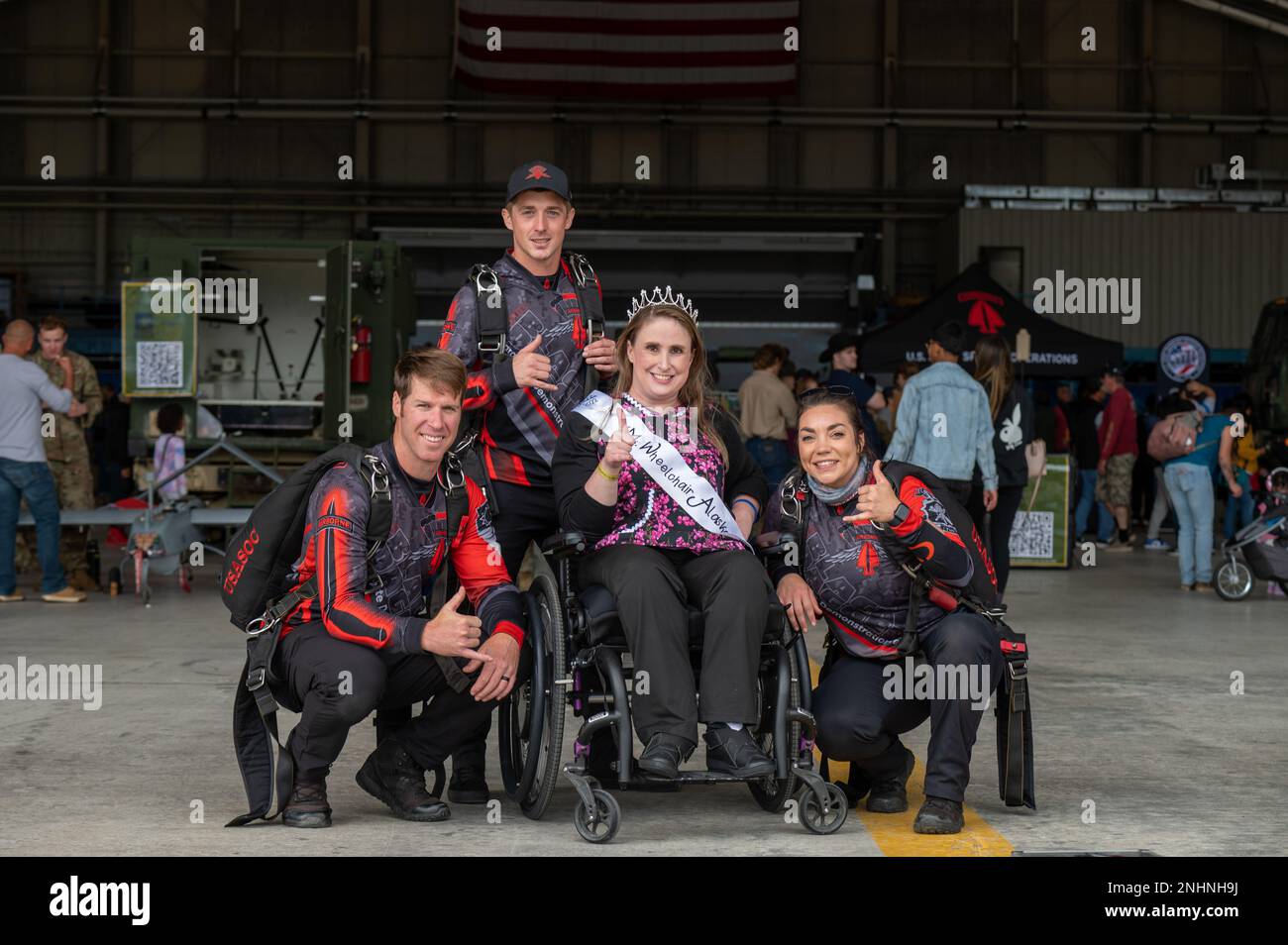 Membri degli Stati Uniti Army Special Operations Command Parachute Demonstration Team, “The Black Daggers”, posa per una foto con la Sig.ra Wheelchair Alaska Christine Burke durante l'Arctic Thunder Open House presso la Joint base Elmendorf-Richardson, Alaska, 30 luglio 2022. I Black Daggers sono composti interamente da volontari provenienti da tutta la comunità delle operazioni speciali dell'esercito. Hanno diversi background e varie specialità militari. Foto Stock