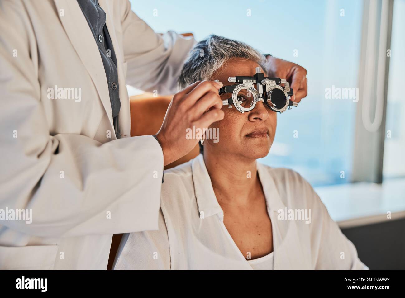 Esame oculare senior, optometristo e esame oculare medico di una donna anziana alla consultazione del medico. Visione, attenzione sanitaria e paziente anziana con Foto Stock