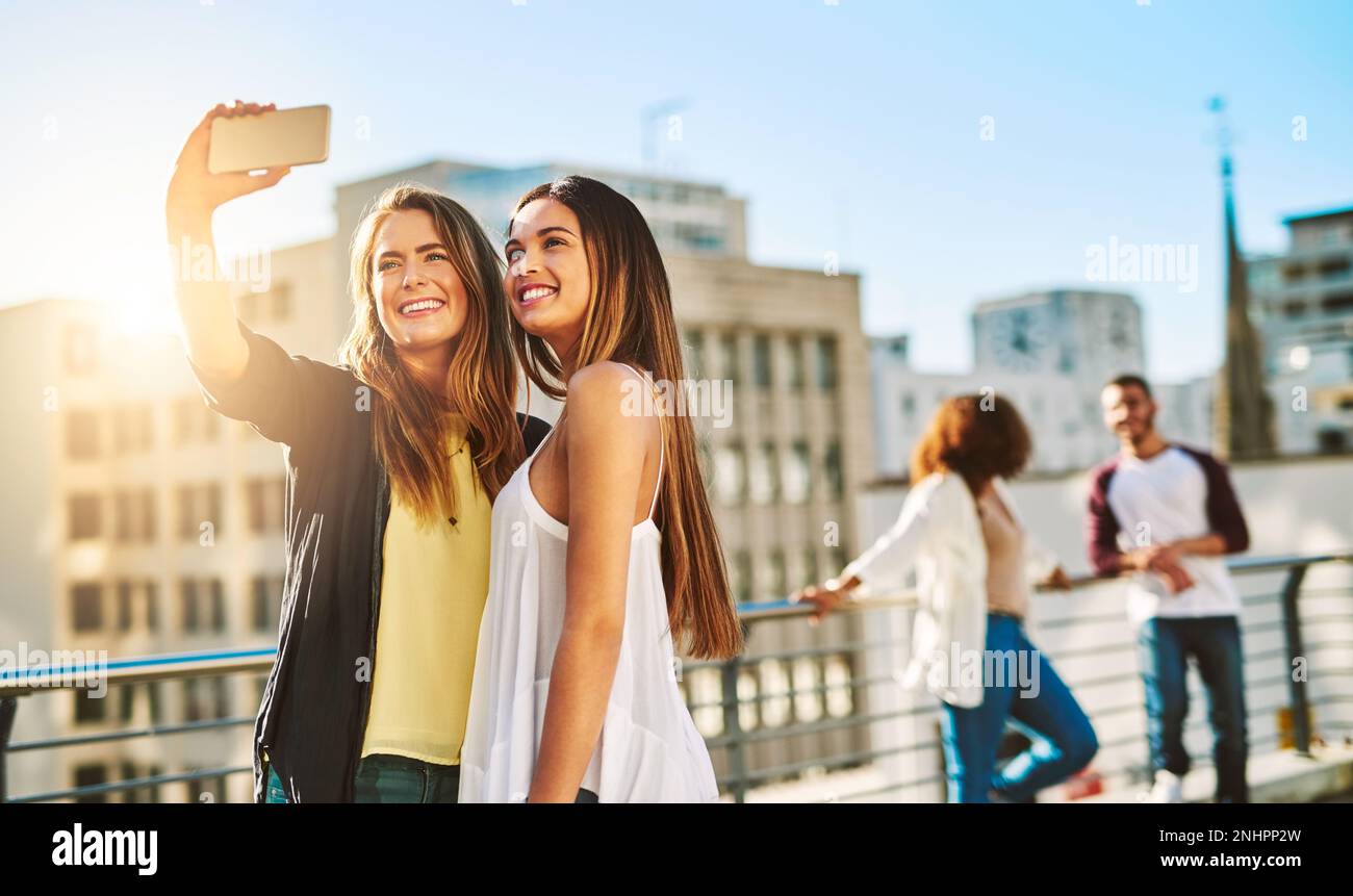 Dire i migliori amici per sempre. giovani amiche che prendono un selfie fuori. Foto Stock