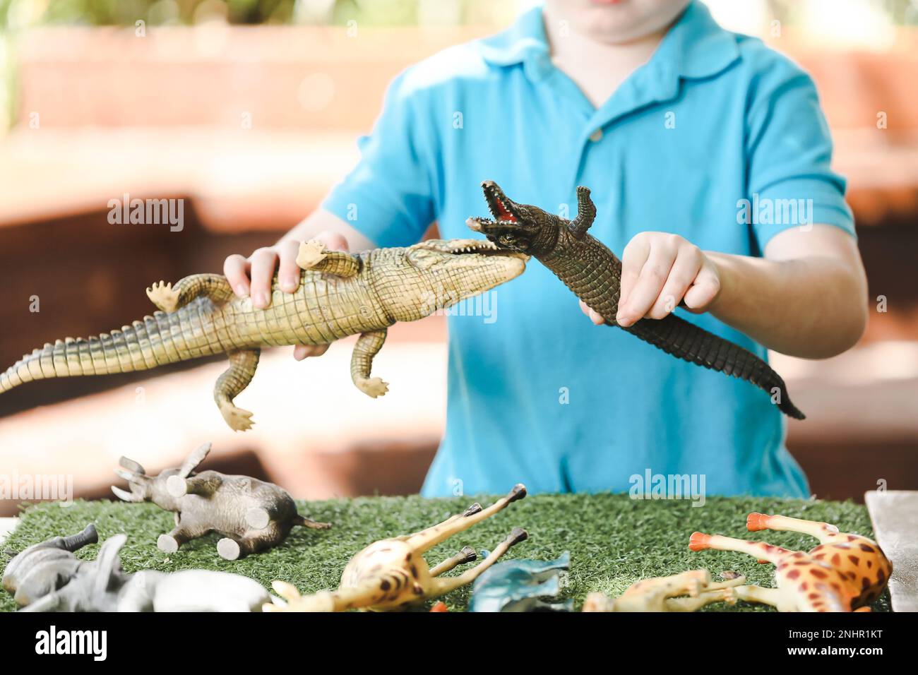 Bambino di prescolare che gioca con il set di giocattoli di animali della giungla. Giochi all'aperto presso l'asilo. Foto Stock