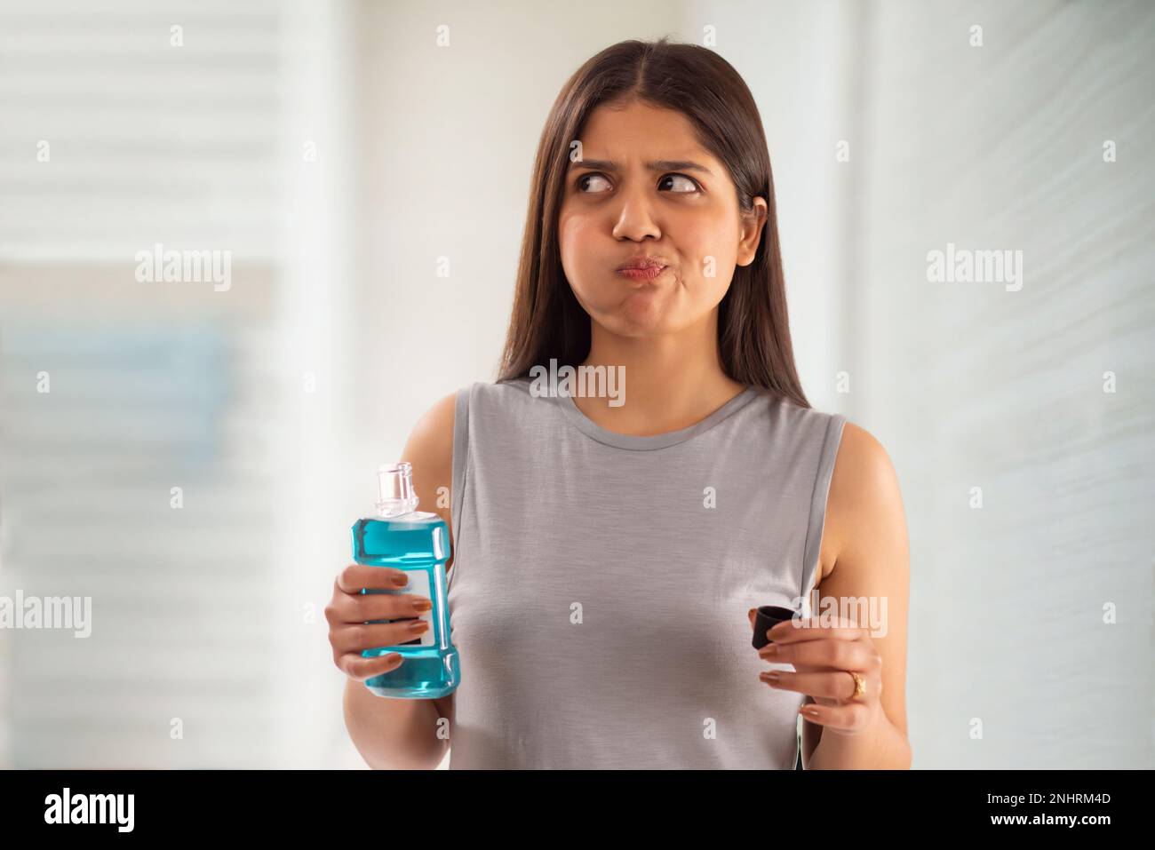 Donna che sciacqua la bocca con collutorio Foto Stock