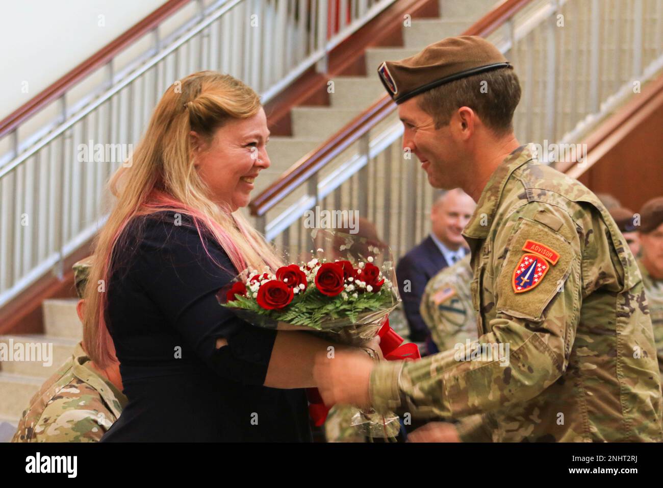 La signora Heather A. Teakell, coniuge del comando Sgt. Maggiore Reese W. Teakell comando uscente Sergente maggiore del comando di assistenza della forza di sicurezza, riceve un bouquet di rose rosse durante una cerimonia di cambio di responsabilità a Fort Bragg, N.C., 2 agosto 2022. La presentazione delle rose è una tradizione che simboleggia la transizione e un nuovo inizio per il rapporto tra il comando e i suoi soldati e le sue famiglie. Foto Stock