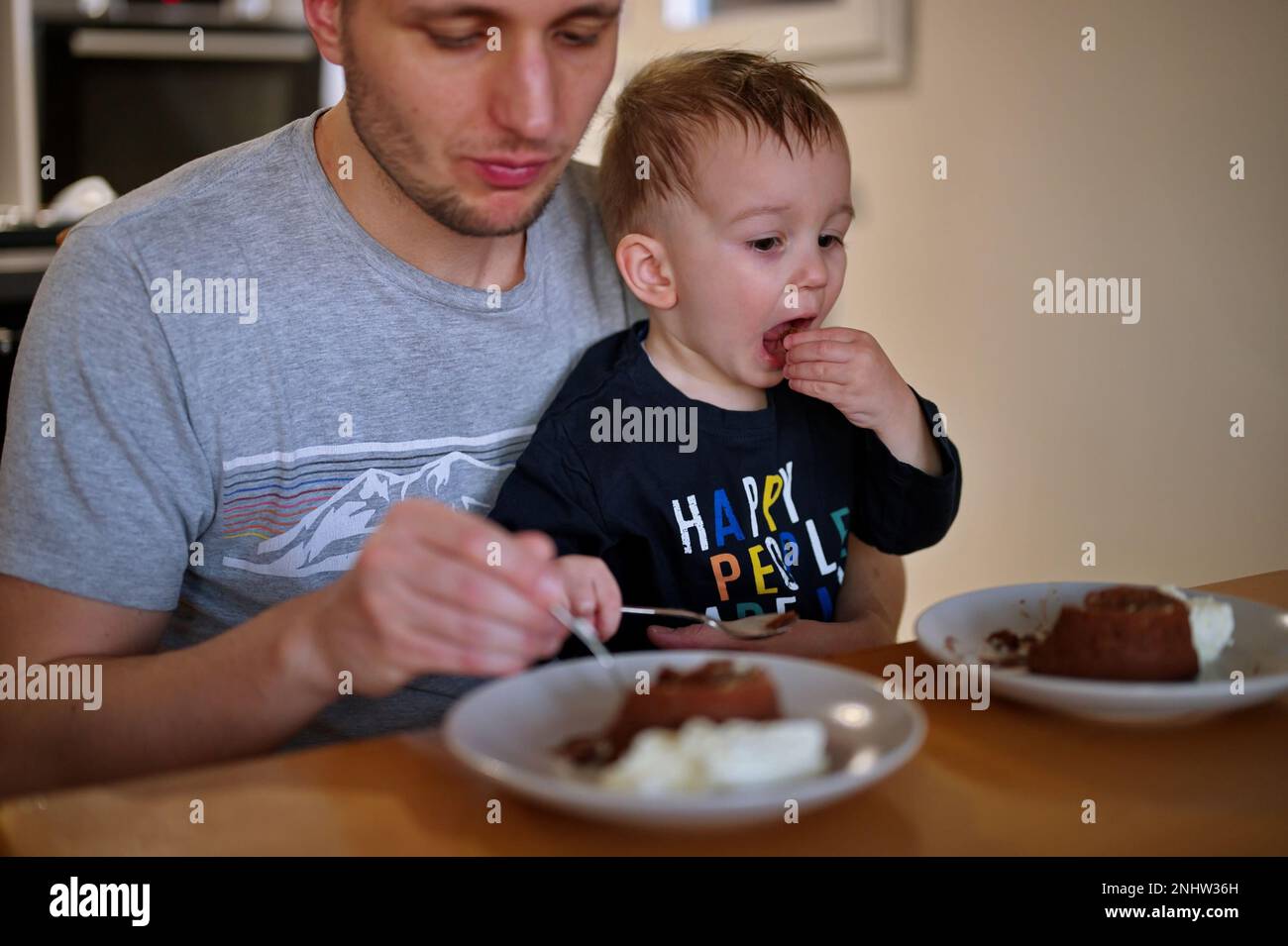 Padre e il suo bambino mangiano torta al cioccolato Foto Stock