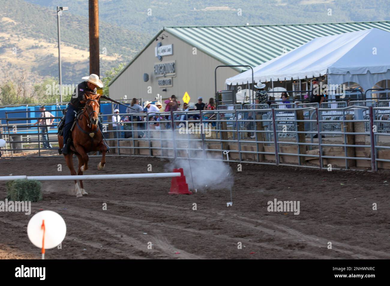 Vincent Aquino, spara il suo obiettivo con un fucile carpino mentre fa un salto alto con Sgt. Slim, il suo cavallo, per la fiera della contea di Garfield, Rifle, Colorado il 3 agosto 2022. Questa prestazione è considerata un salto di alta difficoltà per una coppia che ha cavalcato soltanto insieme per cinque settimane. Foto Stock