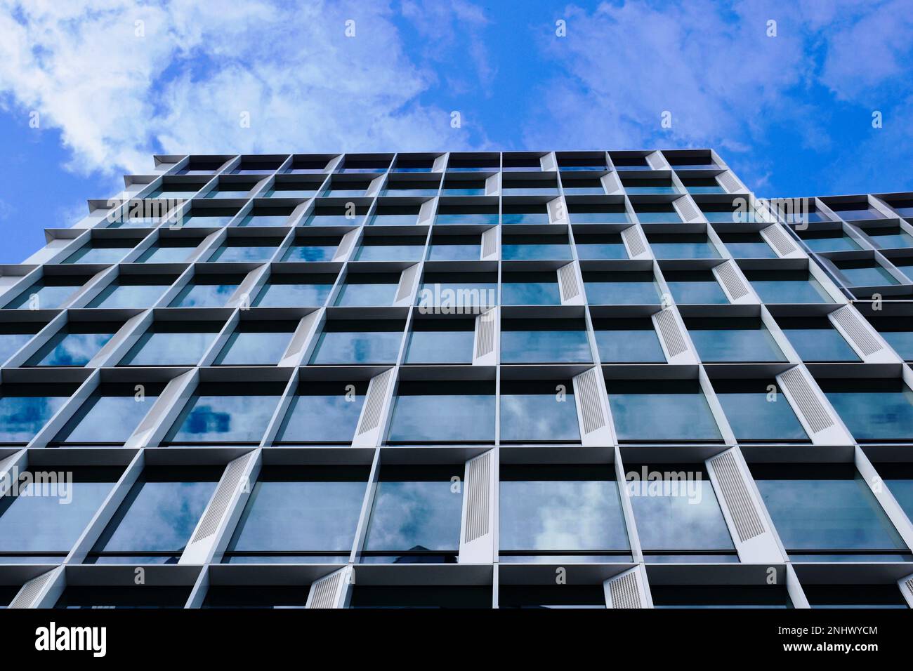 dettaglio della torre di uffici in vetro e alluminio. riduzione della prospettiva. vista astratta ad angolo basso. architettura e design moderni. cielo blu nuvola bianca Foto Stock
