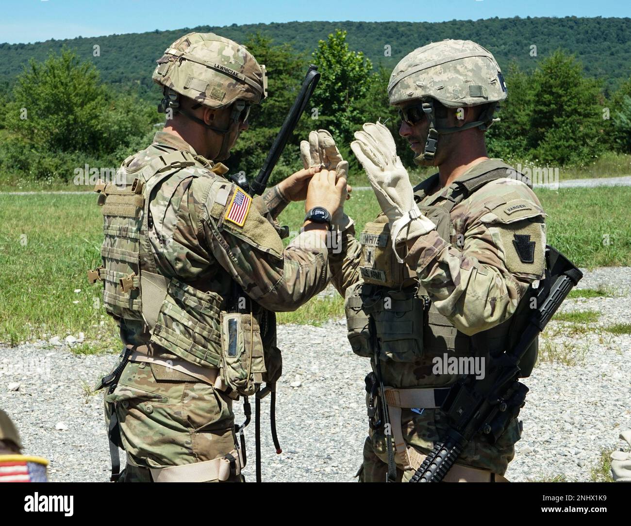 Il maestro di rappello per i soldati con sede centrale e sede centrale, 1st battaglione, 110th reggimento di fanteria, 2nd squadra di combattimento della Brigata di fanteria, controlla i guanti e le attrezzature di ogni soldato prima di iniziare l'addestramento di rappello a Fort Indiantown Gap, Pa., il 3 agosto 2022. I soldati del 1-110th hanno lavorato con i piloti e gli equipaggi della Brigata dell'Aviazione di combattimento Expeditionary 28th per rappel da un falco nero su un campo e poi in seguito su un edificio Foto Stock