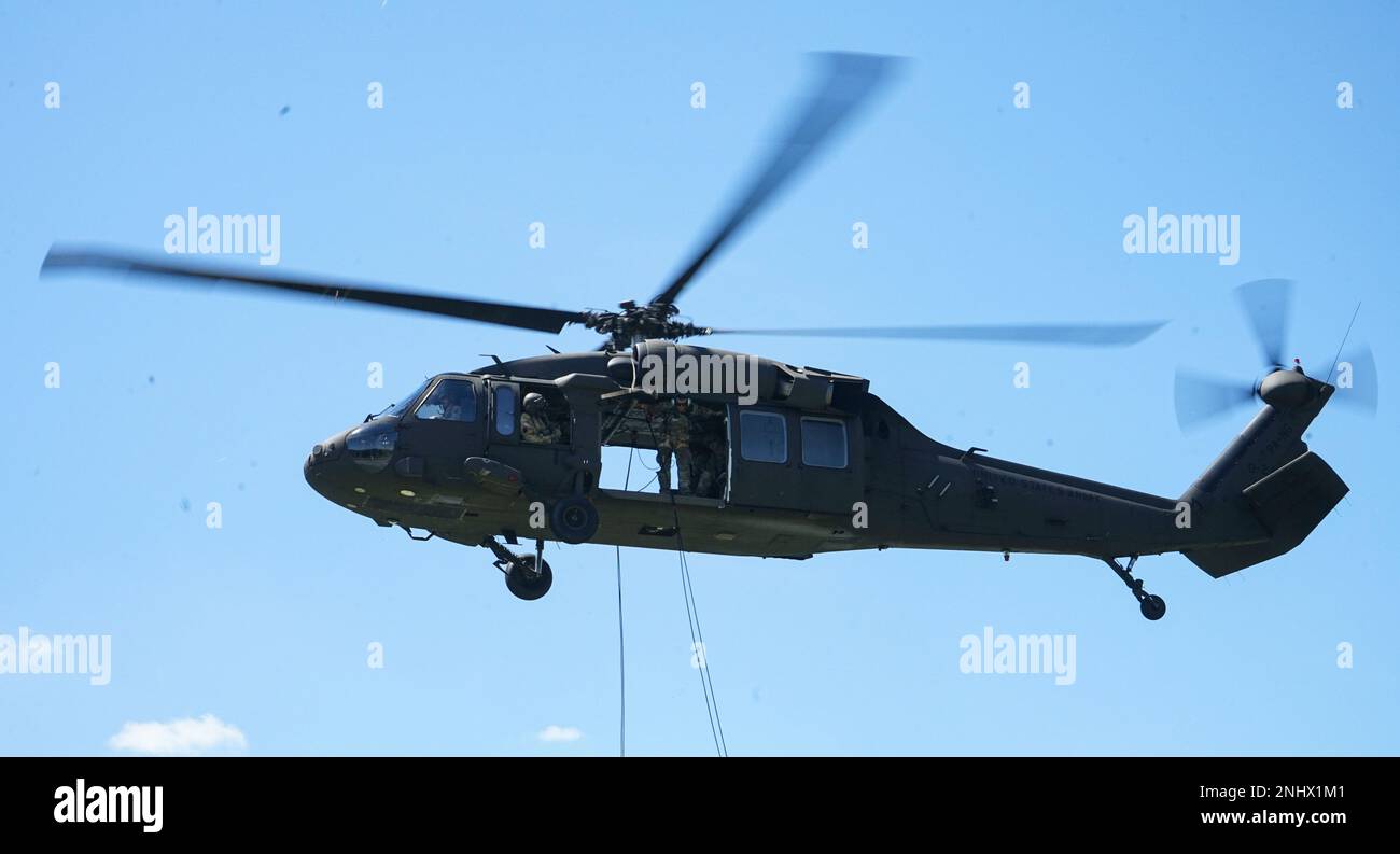 Il maestro del rappel con la sede centrale e la sede centrale, 1st battaglione, 110th reggimento fanteria, 2nd squadra di combattimento della Brigata di fanteria, controlla le linee prima che i soldati si aggrappino e si scoppino durante l'addestramento del rappel a Fort Indiantown Gap, Pa., il 3 agosto 2022. Il maestro del rappel lavora con i piloti e l'equipaggio del falco nero UH-60 per sostenere meglio e coordinare i soldati che rapano a terra Foto Stock