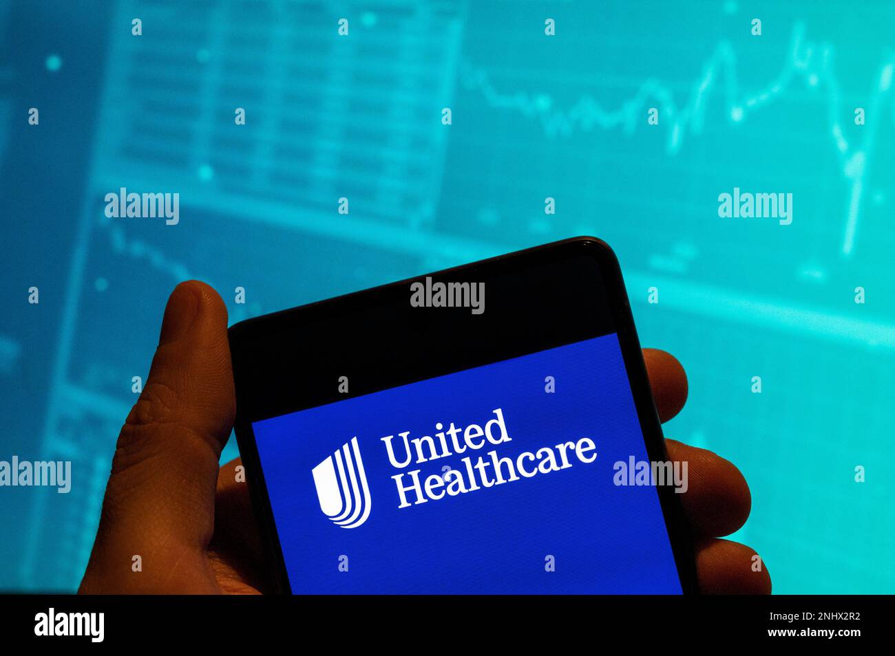 Cina. 15th Feb, 2023. In questa foto, il logo UnitedHealth, società multinazionale americana di assicurazione e assistenza sanitaria, viene visualizzato su uno smartphone con un grafico dell'indice di borsa economica sullo sfondo. (Credit Image: © Budrul Chukrut/SOPA Images via ZUMA Press Wire) SOLO PER USO EDITORIALE! Non per USO commerciale! Foto Stock