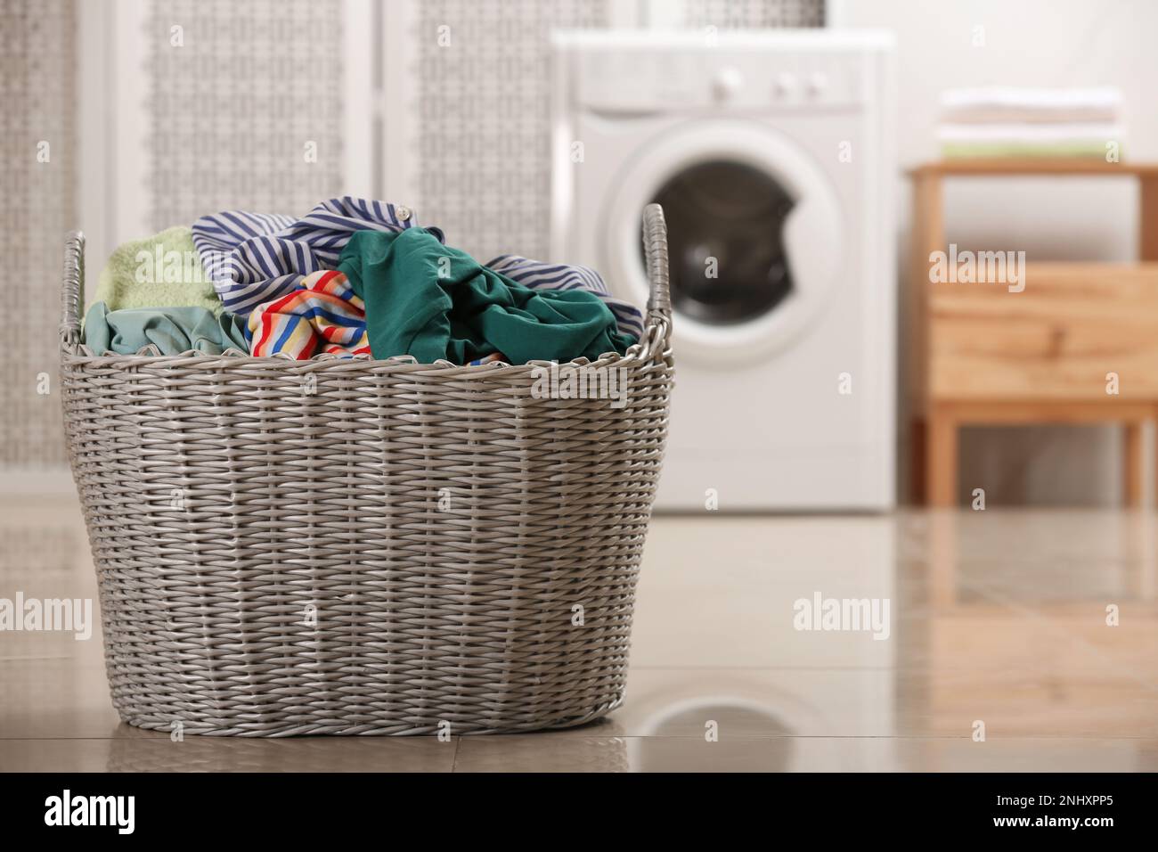 Cestino di vimini con vestiti sporchi sul pavimento nella lavanderia,  spazio per il testo Foto stock - Alamy