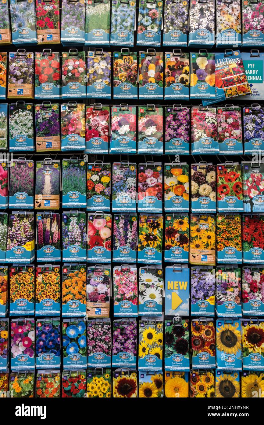 File ordinate di colorati pacchetti di semi di fiore di MR Fothergill appesi al banco espositore nel centro giardino del Regno Unito. Foto Stock