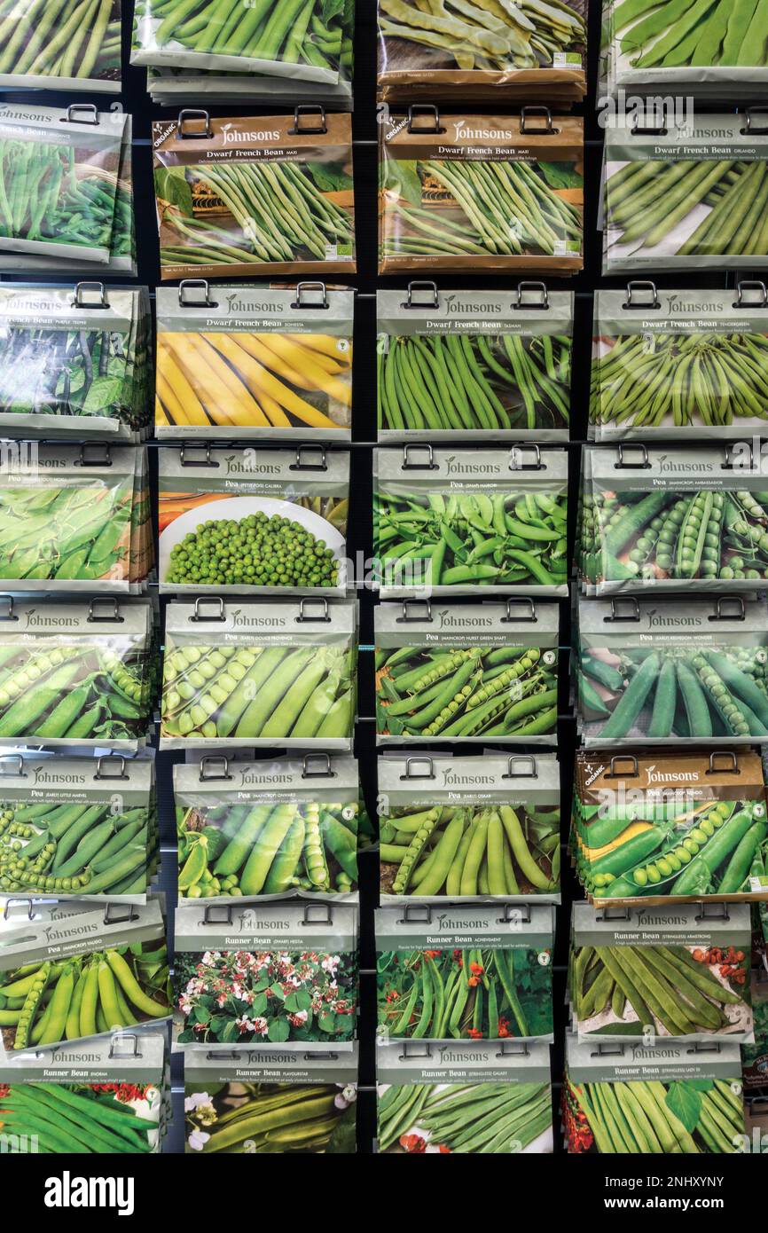 File ordinate di colorati pacchetti di semi di soia e piselli verdi Johnsons appesi al banco espositore nel Garden Center del Regno Unito. Foto Stock