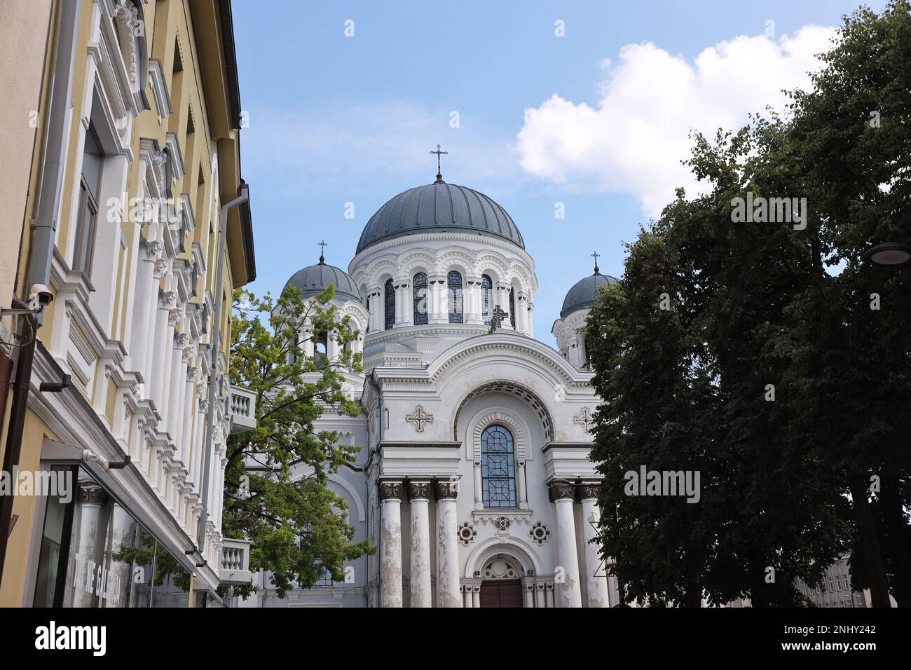 Questa foto cattura l'impressionante vista frontale della Chiesa di San Michele Arcangelo a Kaunas, Lituania, visto da una strada con gli edifici sulla t Foto Stock