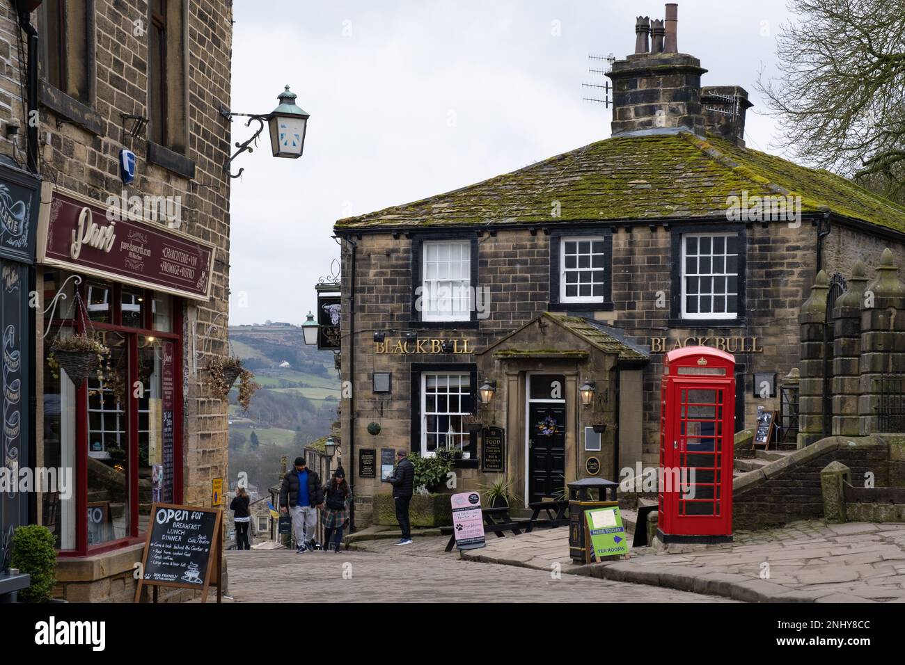 Haworth, West Yorkshire, Regno Unito. La parte superiore di Main Street in Haworth.Haworth è un popolare villaggio famoso per essere la casa delle sorelle del Bronte è popolare Foto Stock
