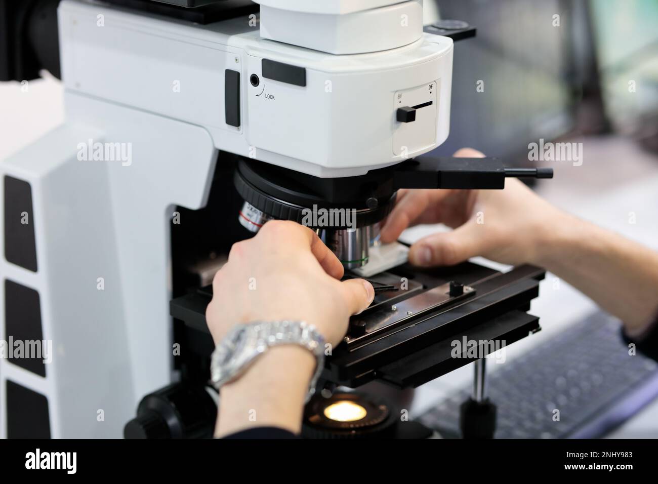 Scienziato che lavora con il microscopio ottico in laboratorio. Messa a fuoco selettiva. Foto Stock