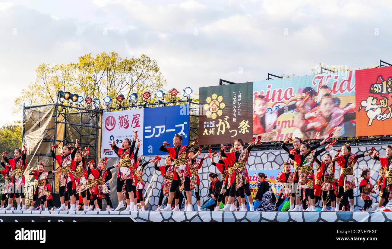 Squadra giapponese di danzatrici Yosakoi bambini ballare e tenere naruko e tifosi sul palco all'aperto al festival Kyusyu Gassai a Kumamoto. Foto Stock