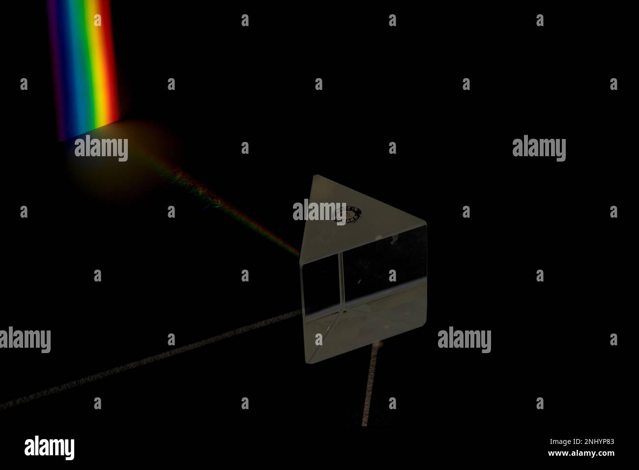 Fascio di luce bianca diviso da un prisma di vetro equilatero, dispersione, nelle lunghezze d'onda dello spettro proiettate su uno schermo, luci arcobaleno Foto Stock