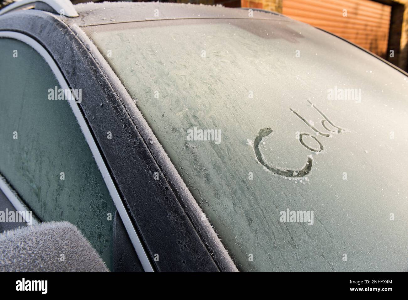Brina brina e temperatura inferiore allo zero lasciano il parabrezza dell'auto ricoperto da uno strato di ghiaccio brina che deve essere eliminato prima della guida, messaggio freddo congelato Foto Stock