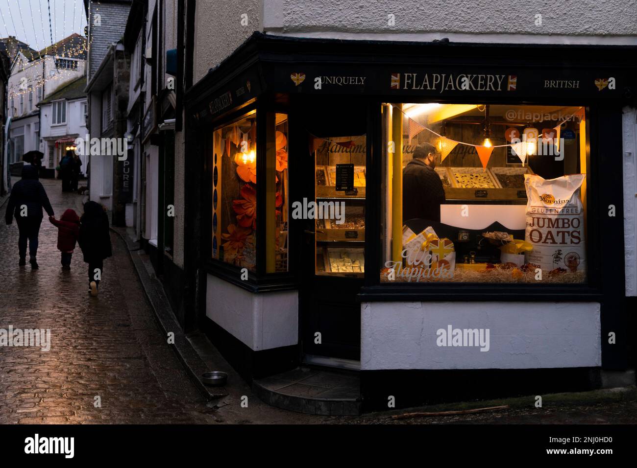 Il negozio Flapjackery di Fore Street apre durante la forte pioggia in bassa stagione a St Ives in Cornovaglia in Inghilterra nel Regno Unito. Foto Stock