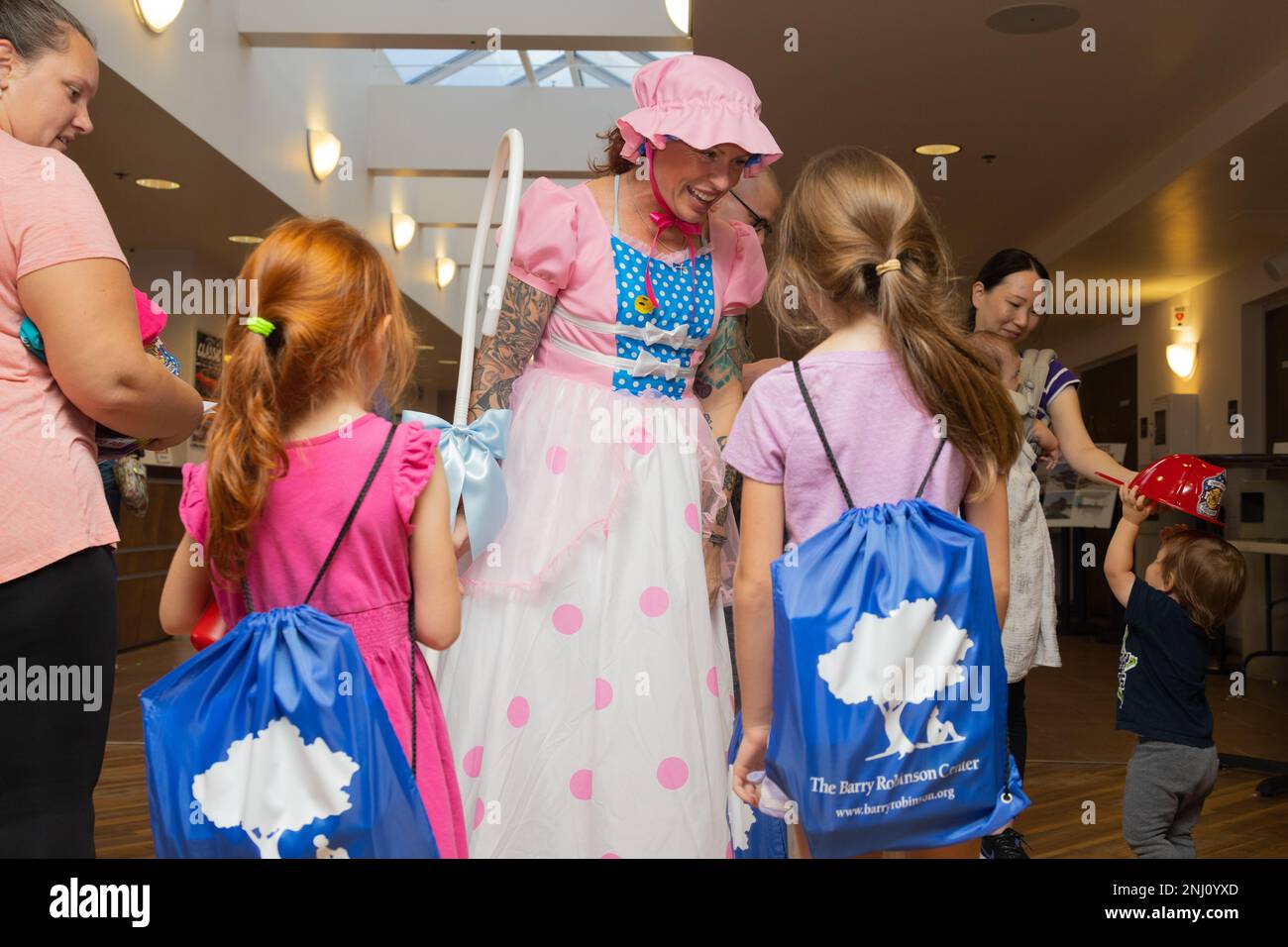 Un volontario vestito come Bo Peep da ‘Toy Story’ parla con i bambini al Back to School Readiness Roundup al Two Rivers Theater and Event Center sulla Marine Corps Air Station Cherry Point, North Carolina, 4 agosto 2022. L'evento a tema "Toy Story" organizzato dai Marine Corps Community Services è stato un'opportunità per le famiglie militari di connettersi con l'ufficiale di collegamento della scuola, scoprire le risorse di preparazione della famiglia, divertirsi con la famiglia e procurarsi alcuni materiali scolastici gratuiti per prepararli per l'anno scolastico 2022-2023. Foto Stock