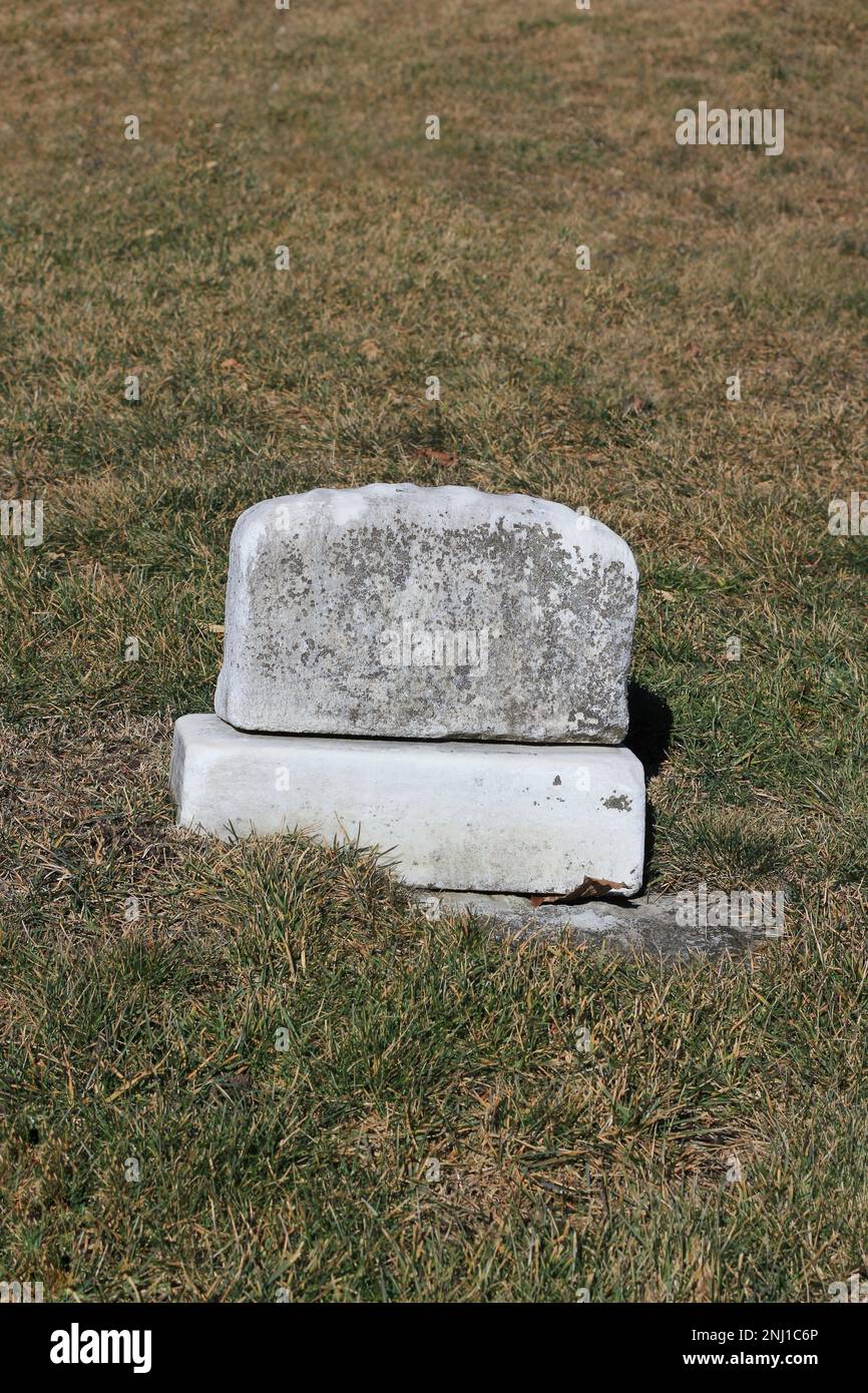 Una vecchia lapide usurata e intatta con un epitaffio bianco e spazio per il testo. Foto Stock