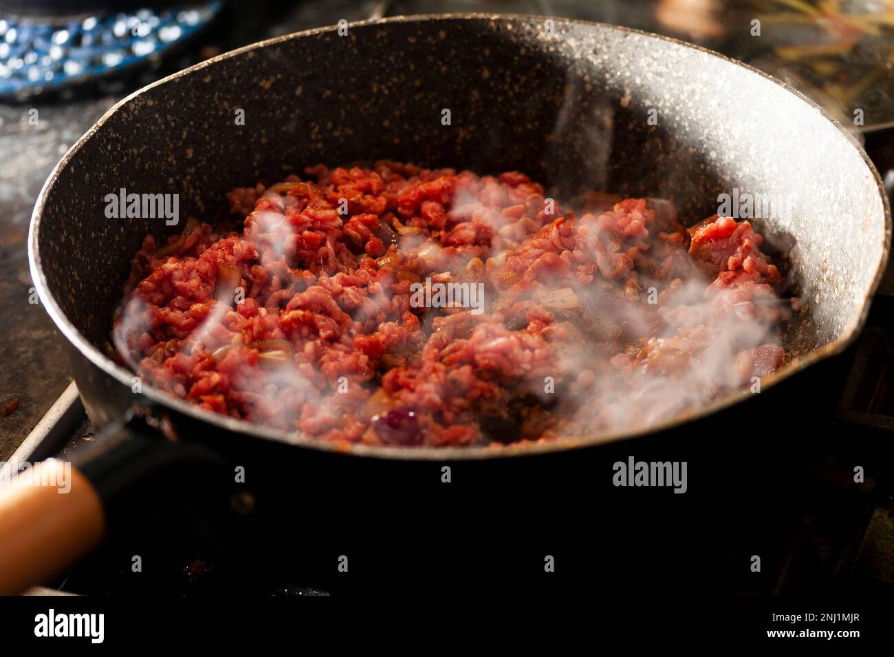 La Bolognaise viene cucinata con cipolla in padella. home cibo cotto intero biologico Foto Stock