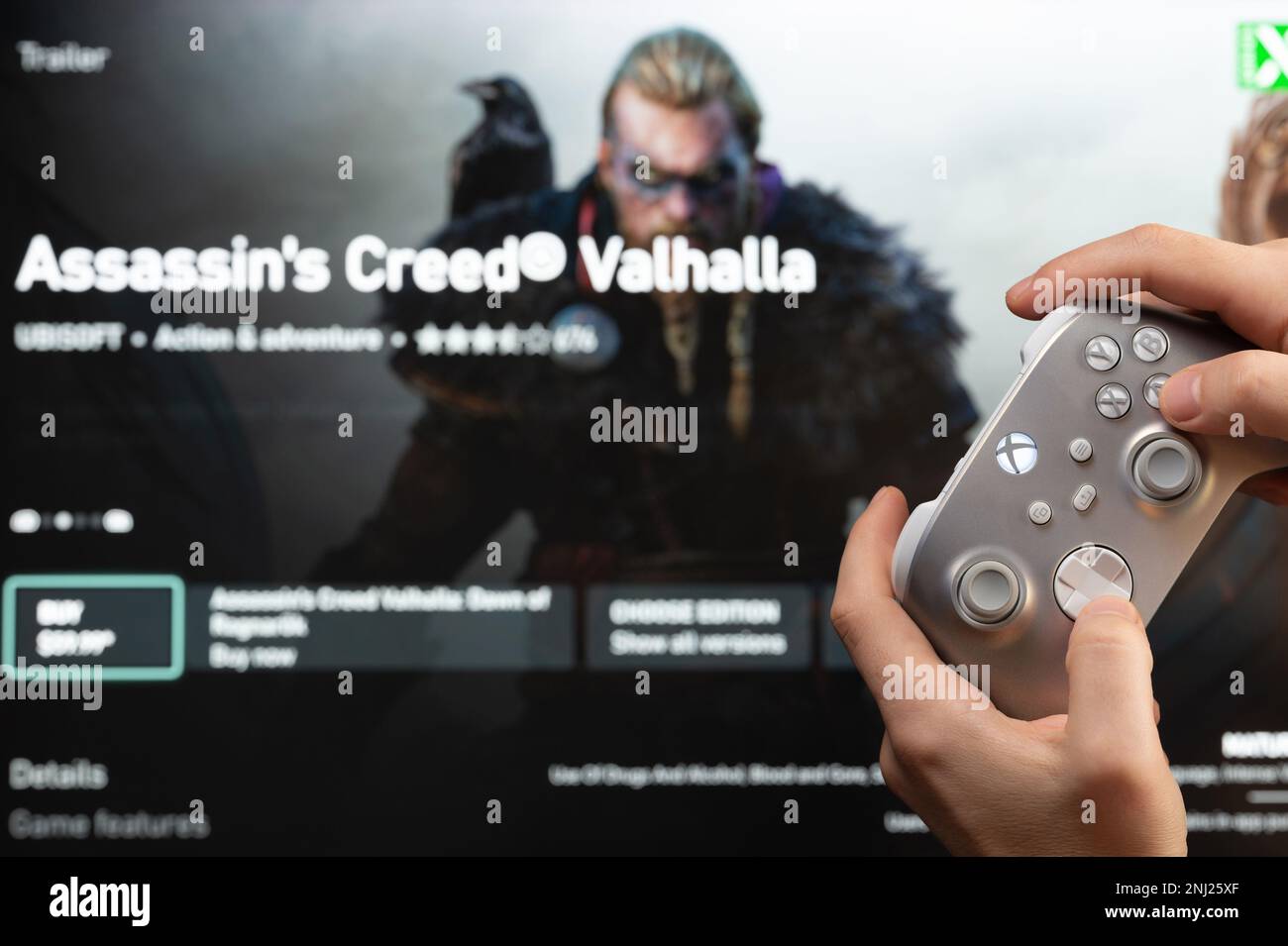 New york, USA - 20 febbraio 2023: Acquista il nuovo gioco Assassin's Creed valhalla nel negozio online microsoft xbox con controller gamepad in mano Foto Stock