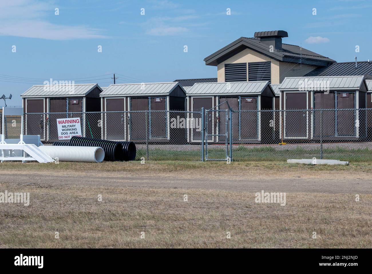 Canili temporanei occupano la parte anteriore del 341st forze di sicurezza Squadron militare lavoro composto cane durante la costruzione di canile al coperto 4 agosto 2022, presso la base dell'aeronautica militare di Malmstrom, Month. I lavori di ristrutturazione del complesso includono l'aggiornamento delle canne da interno con un impianto idraulico, l'installazione di luci esterne per l'allenamento notturno e la sostituzione delle attuali strutture del corso a ostacoli in vinile con sostituti permanenti in cemento. Foto Stock