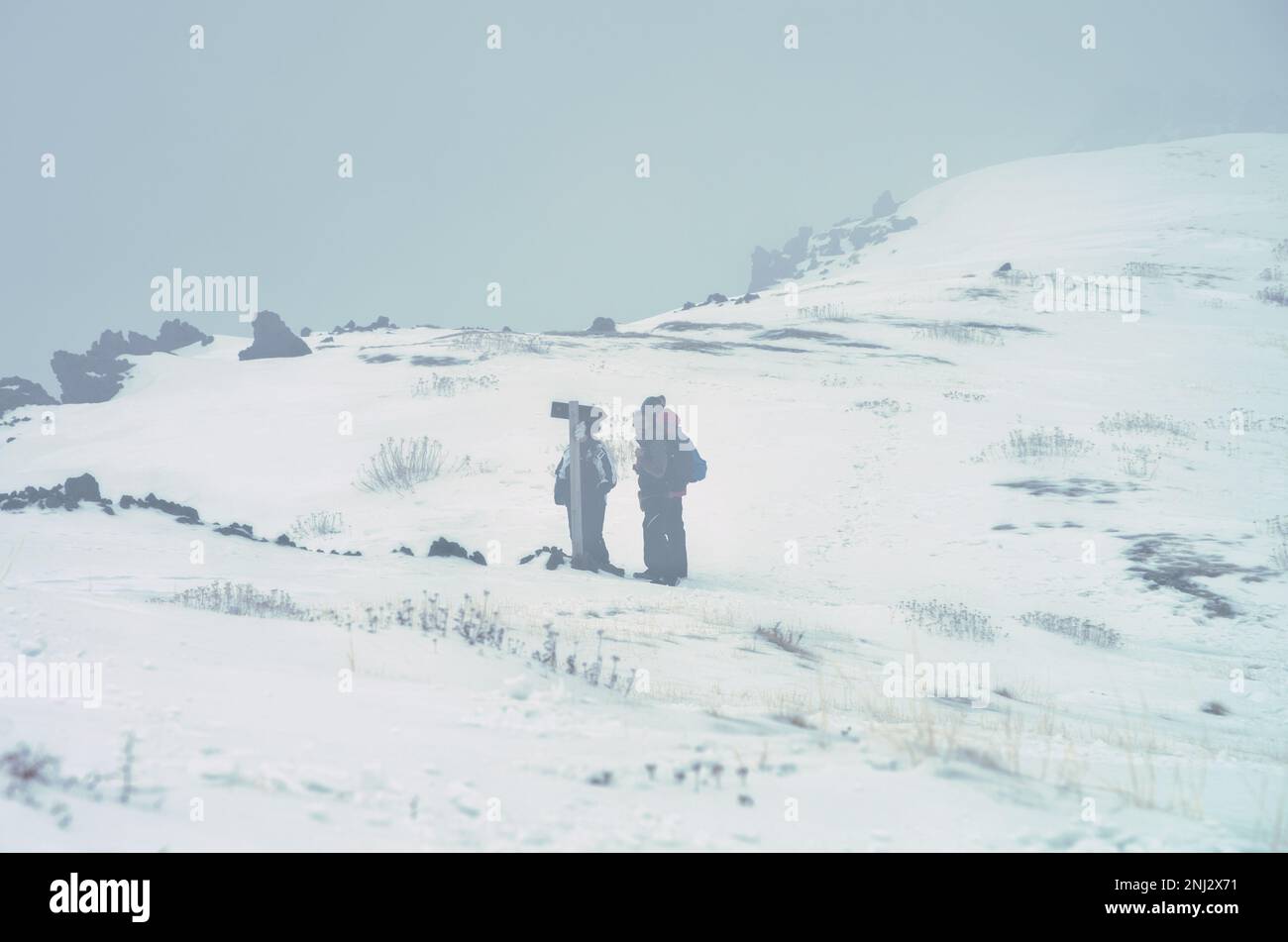Piccolo gruppo di persone nella nebbia sulla 'Schiena dell'Asino' nel Parco Nazionale dell'Etna, ai margini della 'Valle del Bove', Sicilia, Italia Foto Stock