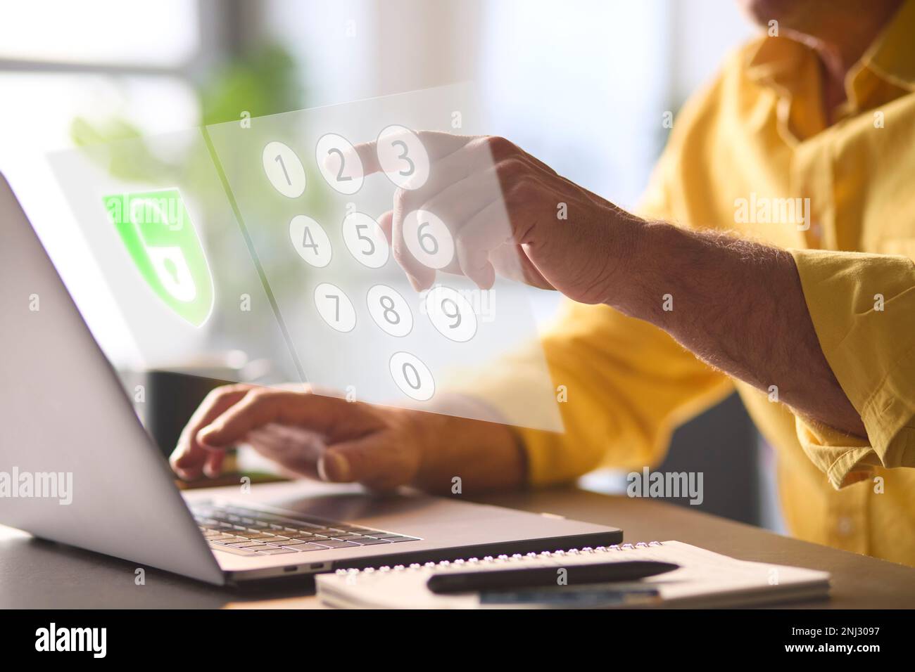 Concetto di sicurezza online con uomo che utilizza il laptop con sovrapposizione grafica di blocco e tastierino con numeri PIN Foto Stock