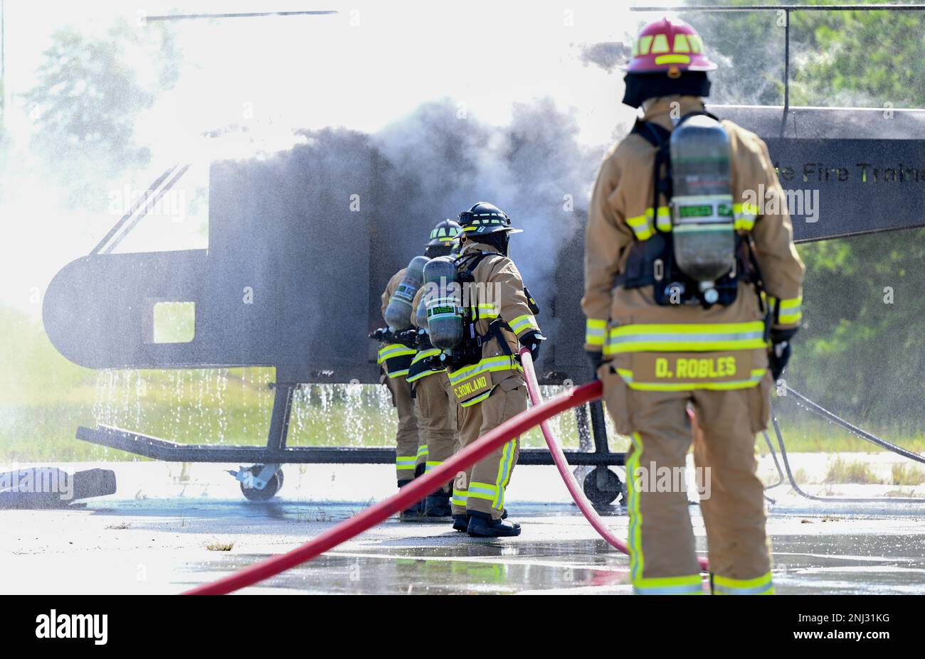 STATI UNITI I vigili del fuoco dell'aeronautica con lo Squadron dell'ingegnere civile del 908th spengono completamente un incendio interno dell'aeromobile durante un esercizio di formazione congiunto sull'interoperabilità, il 4 agosto 2022, a Fort Benning, Georgia. Questa è la prima volta che vengono presentati a un addestratore di elicotteri in preparazione della transizione della 908th Airlift Wing alla missione di addestramento per elicotteri MH-139A Grey Wolf. Foto Stock